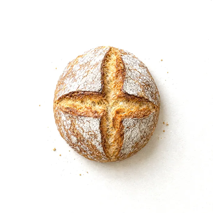 A crusty round loaf with a cross-shaped score.